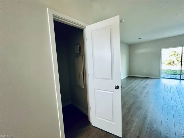 Corridor featuring dark wood finished floors and electric panel