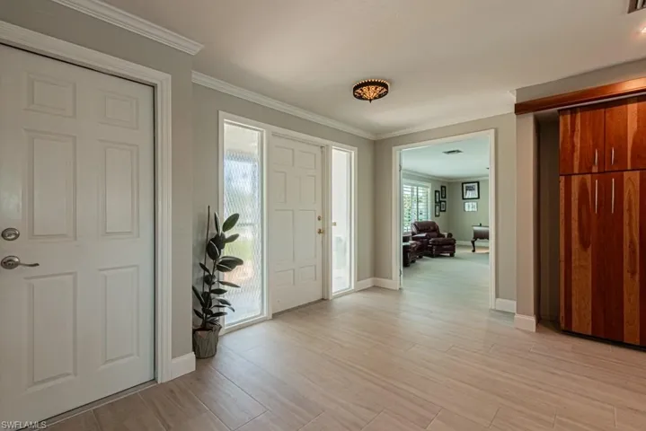 Entrance foyer featuring ornamental molding and wood tiled floors