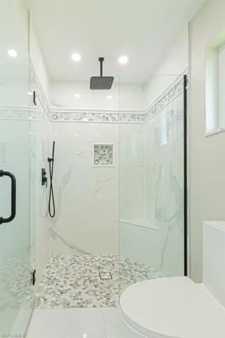Full bathroom with a marble finish shower and recessed lighting