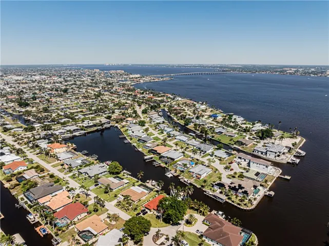 Aerial overview of property's location featuring a large body of water, nearby suburban area, and a notable bridge