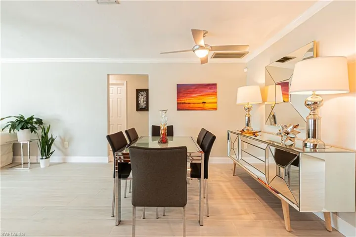 Dining room featuring ornamental molding, a ceiling fan, and light wood-type flooring