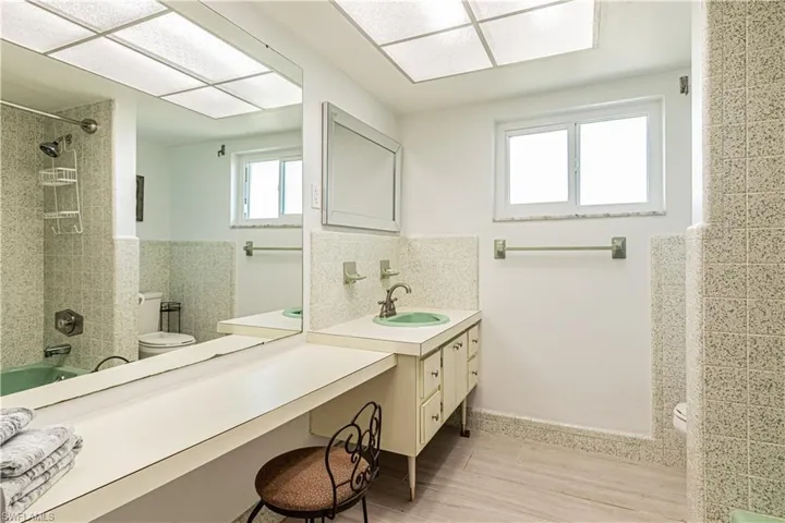 Full bathroom featuring vanity, shower / tub combination, light wood-style flooring, and tasteful backsplash