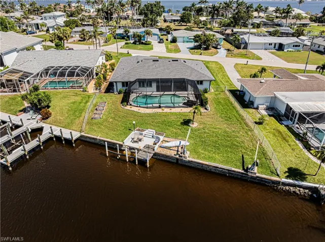 Aerial view of residential area with a nearby body of water and a pool