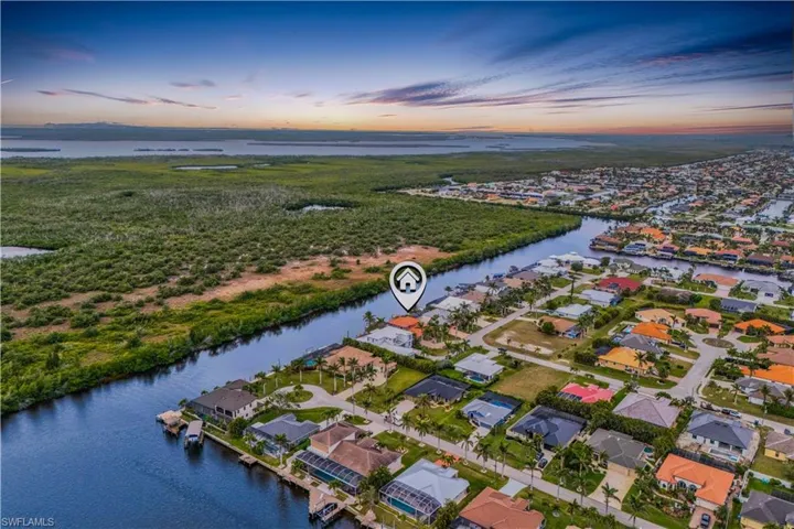 Aerial view at dusk featuring a water view