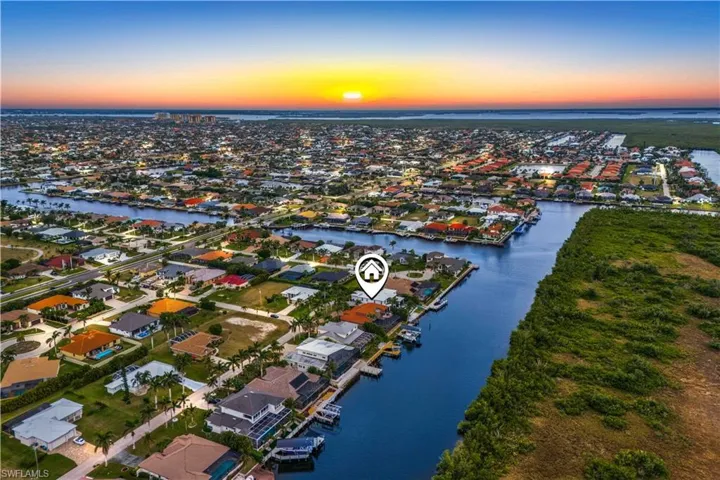 Aerial view at dusk featuring a water view
