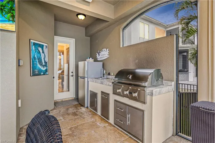 Outdoor kitchen with grill, fridge, icemaker and easy access to the bathroom.