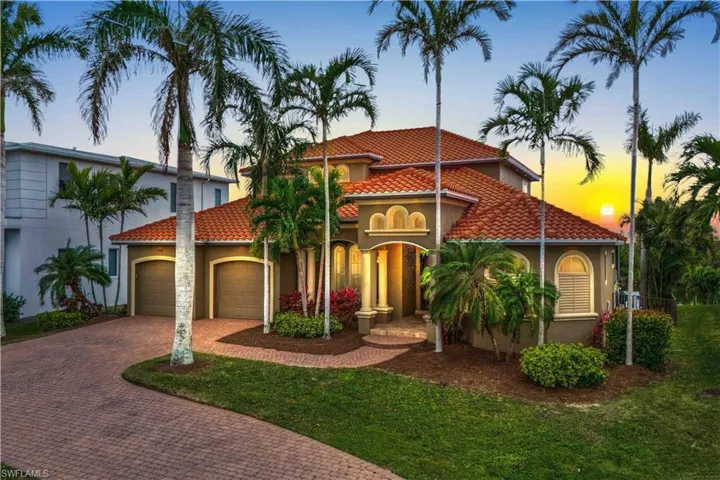 Front of home with the magnificent sunset right in your back yard!  Long driveway and beautiful Royal Palm Trees lining the entry!