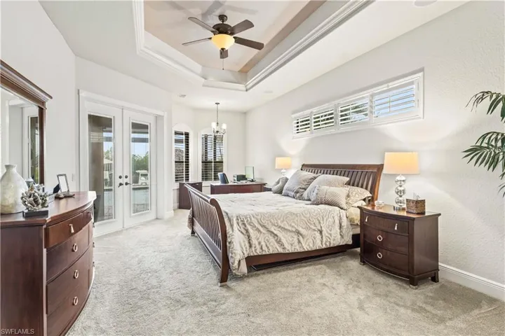 Downstairs main master bedroom with french doors to the outside patio, a sitting area/ working area and it is HUGE!!!!!!  Will easily handle large furniture combinations and is accented by a beautiful tray ceiling with crown molding and plantation shutters and upgraded window treatments!