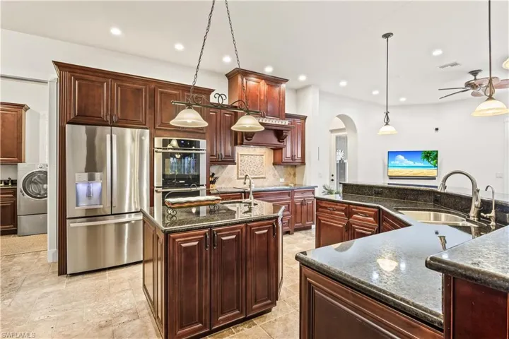 Gourmet Chef's kitchen with double ovens, custom cabinetry, a prep sink in the island - a perfect place to host your friends and family!  Upgraded stainless steel appliances, multiple surface areas and tons of storage.
