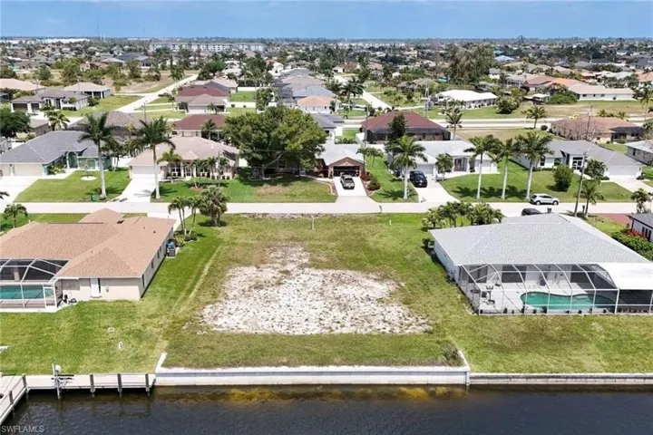 Aerial view of residential area featuring a nearby body of water