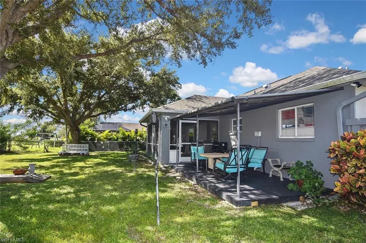 Rear view of house featuring stucco siding, a shingled roof, and a deck