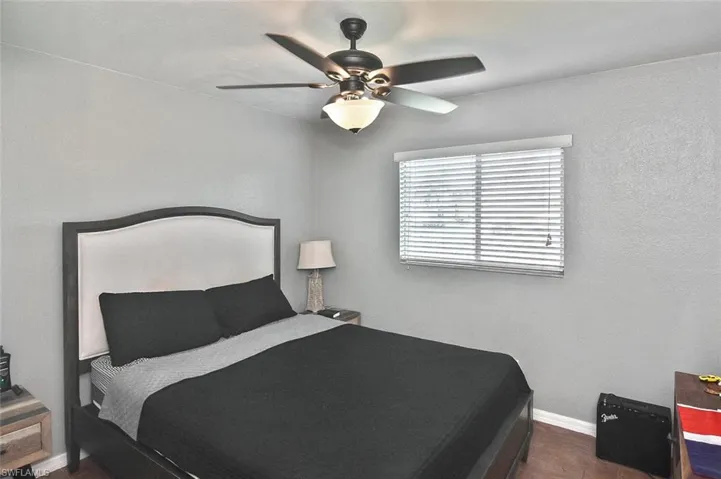 Bedroom with a ceiling fan and a textured wall