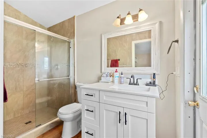 Glass-enclosed shower with tile surround and mosaic accent