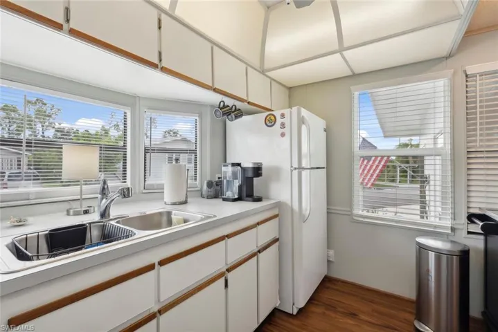 Kitchen with white cabinets, sink, hardwood / wood-style flooring, and white refrigerator