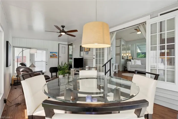 Dining space with hardwood / wood-style floors and ceiling fan with notable chandelier