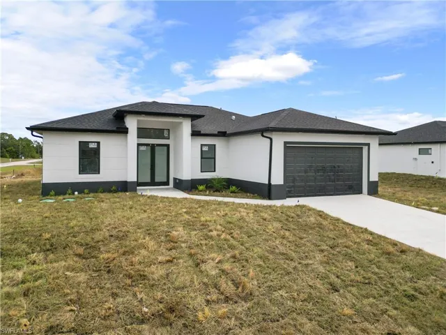 Prairie-style home featuring a front lawn and a garage