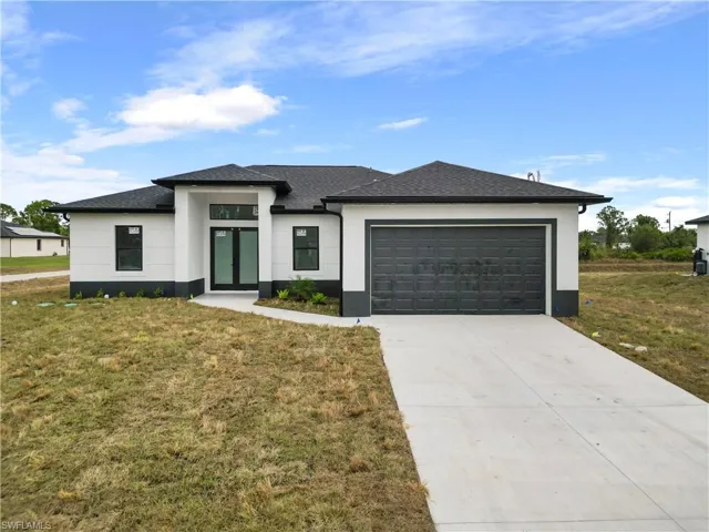 View of front of home with a garage and a front lawn