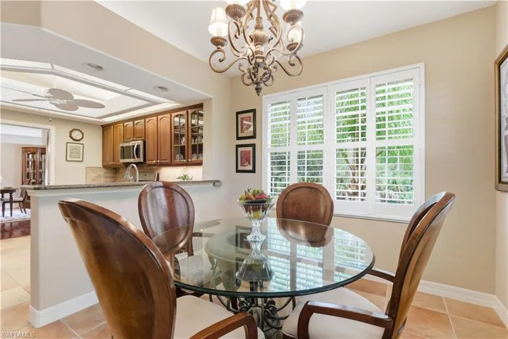 Dining space featuring light tile patterned floors, a chandelier, and ceiling fan