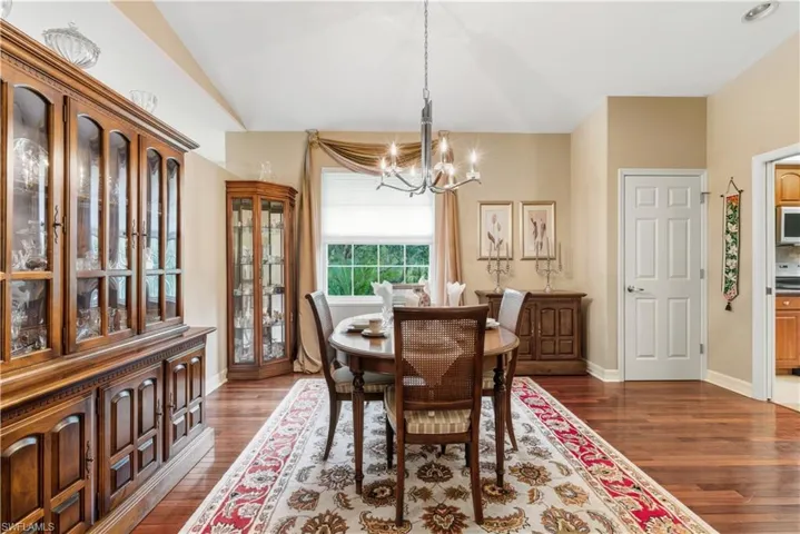 Dining area with dark wood-style flooring and a chandelier