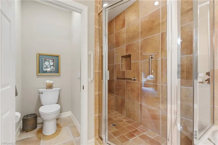 Bathroom with a stall shower and tile patterned floors