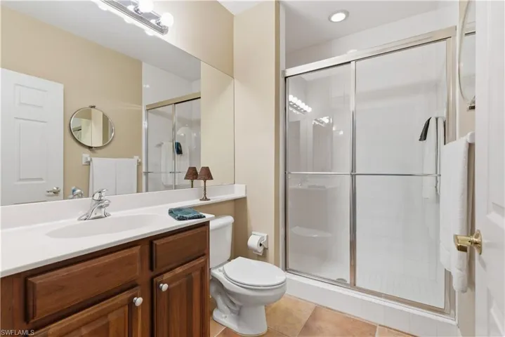 Full bathroom with light tile patterned floors, vanity, and a stall shower