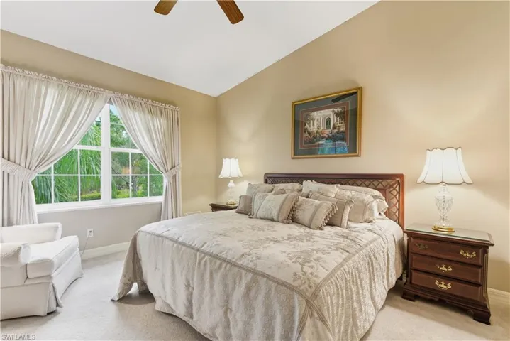 Bedroom featuring carpet flooring, lofted ceiling, and a ceiling fan