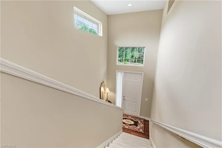 Foyer with wood finished floors and a towering ceiling
