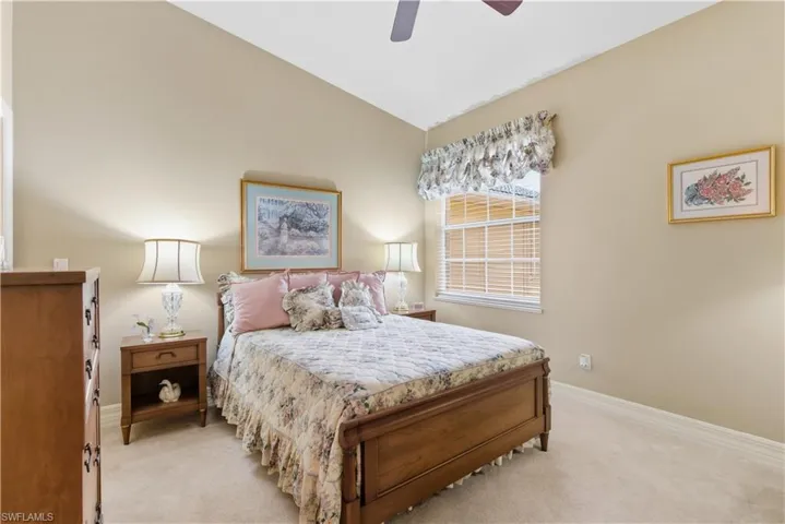 Carpeted bedroom with lofted ceiling and ceiling fan