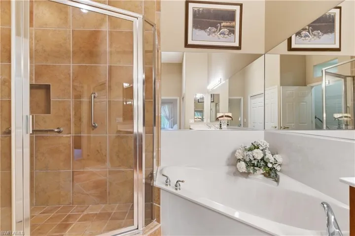 Bathroom featuring a bath, a stall shower, and vanity