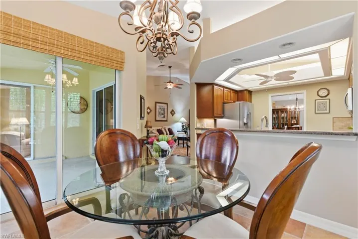 Dining room featuring a chandelier, light tile patterned flooring, and a ceiling fan