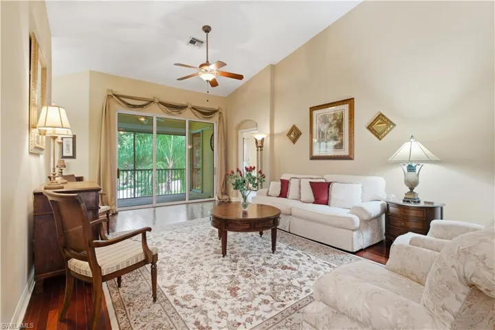 Living room featuring wood finished floors, ceiling fan, and lofted ceiling