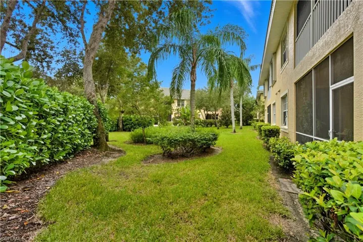 View of grassy yard with a sunroom