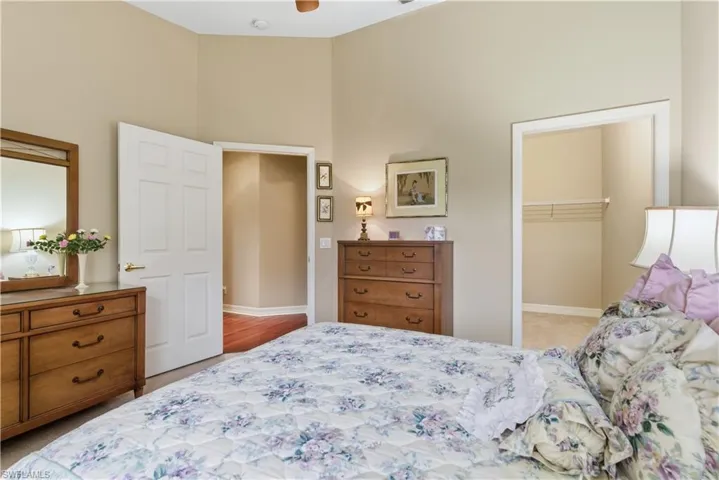 Bedroom featuring a walk in closet and light colored carpet