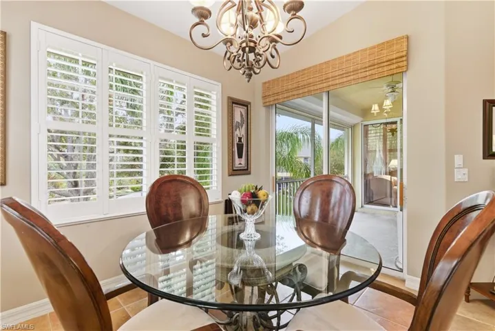 Tiled dining room featuring a chandelier and ceiling fan