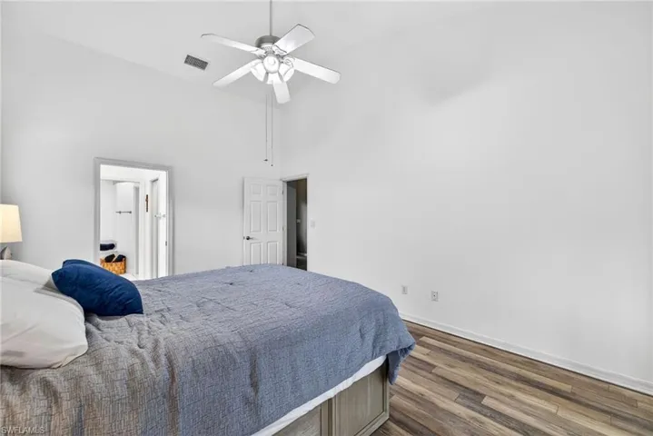 Bedroom featuring dark wood-type flooring, ceiling fan, and vaulted ceiling