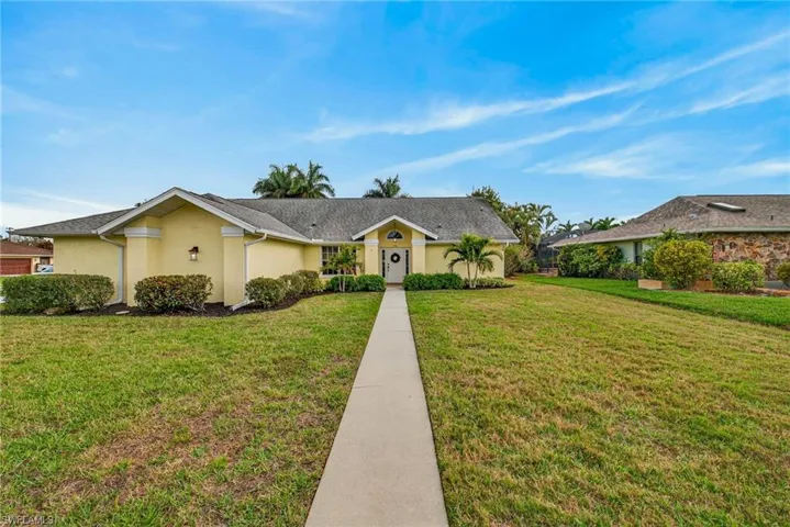 Single story home with a front lawn and stucco siding