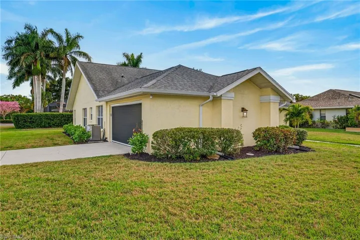 View of front of home featuring a front lawn, stucco siding, driveway, a garage, and a shingled roof