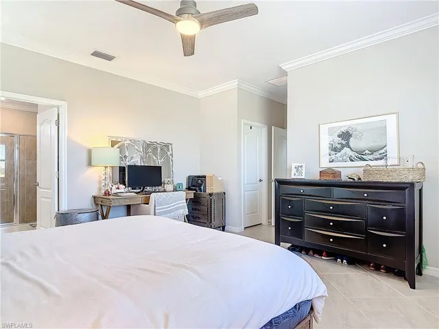 Bedroom featuring light tile patterned flooring, ceiling fan, and crown molding