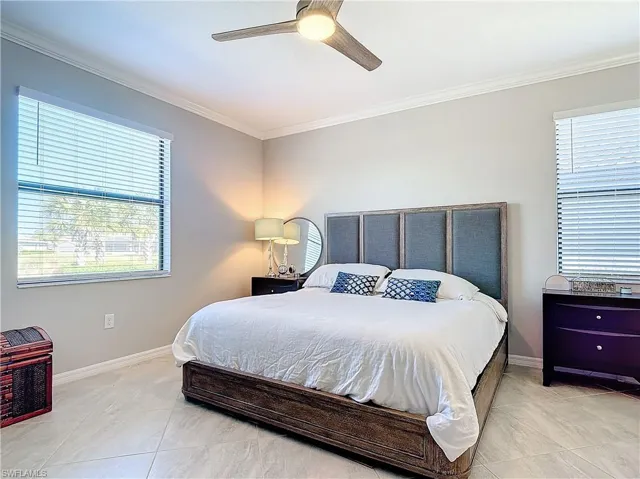 Tiled bedroom with ceiling fan and crown molding