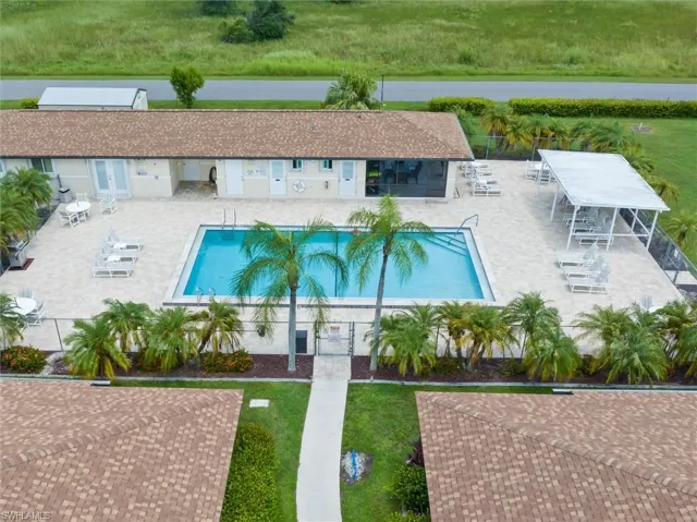 View of pool featuring a lawn, a water view, and a patio area