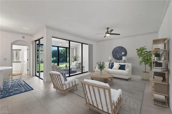Living room with ornamental molding, light tile patterned floors, and ceiling fan