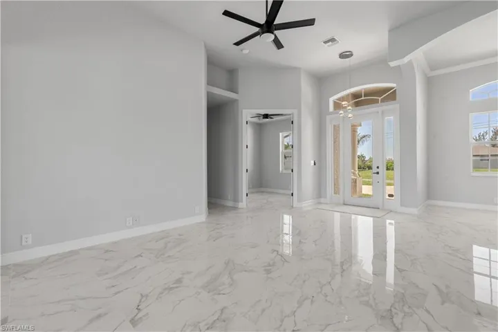 Empty room featuring light tile patterned flooring and ceiling fan