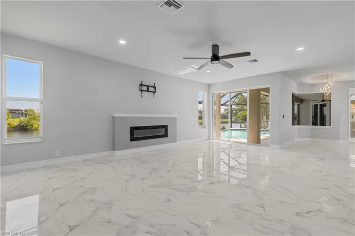 Unfurnished living room featuring light tile patterned flooring and ceiling fan