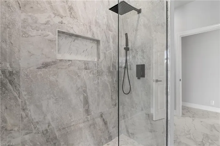 Bathroom with tiled shower and tile patterned flooring