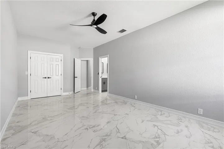 Unfurnished bedroom with a closet, light tile patterned floors, and ceiling fan