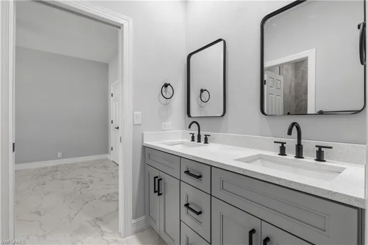 Bathroom with tile patterned flooring and dual bowl vanity