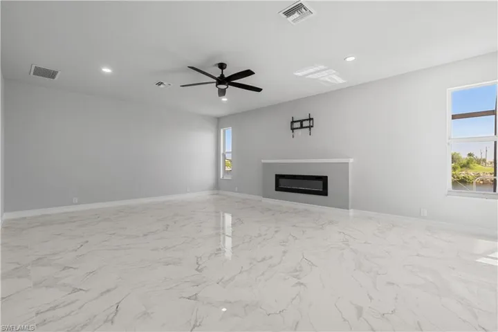 Unfurnished living room featuring light tile patterned floors and ceiling fan