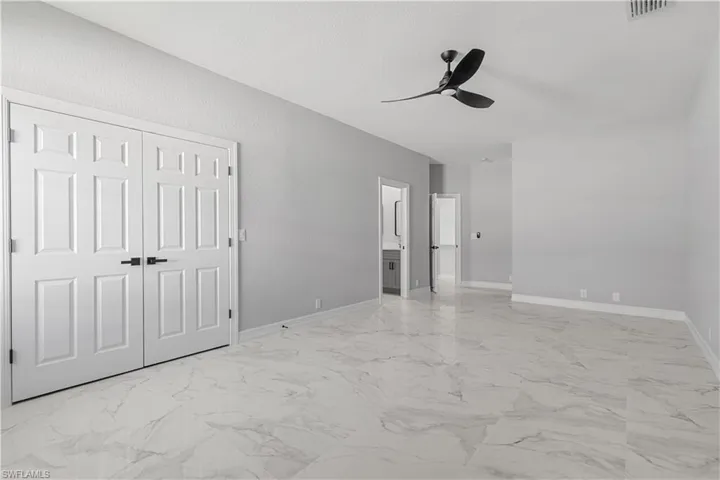 Empty room with light tile patterned floors and ceiling fan