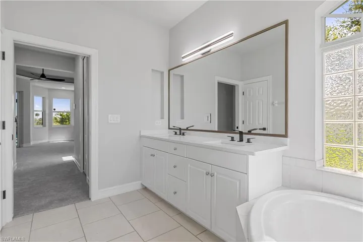 Bathroom with tile patterned flooring, a wealth of natural light, and ceiling fan