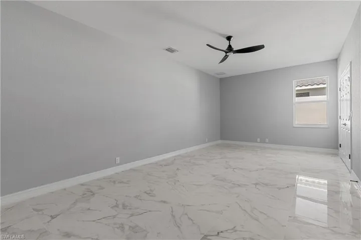 Spare room with ceiling fan and light tile patterned floors